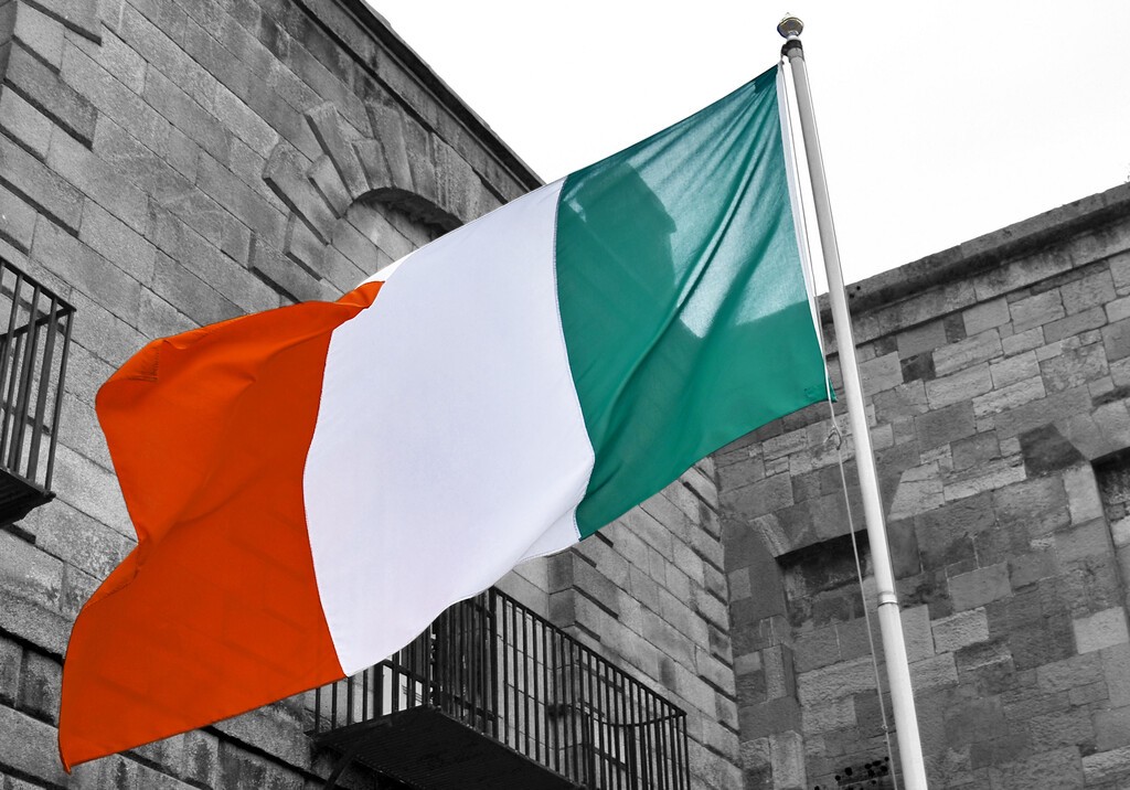 Ó strainséirí ar son dlúthpháirtíochta; bratach thrídhathach na hÉireann